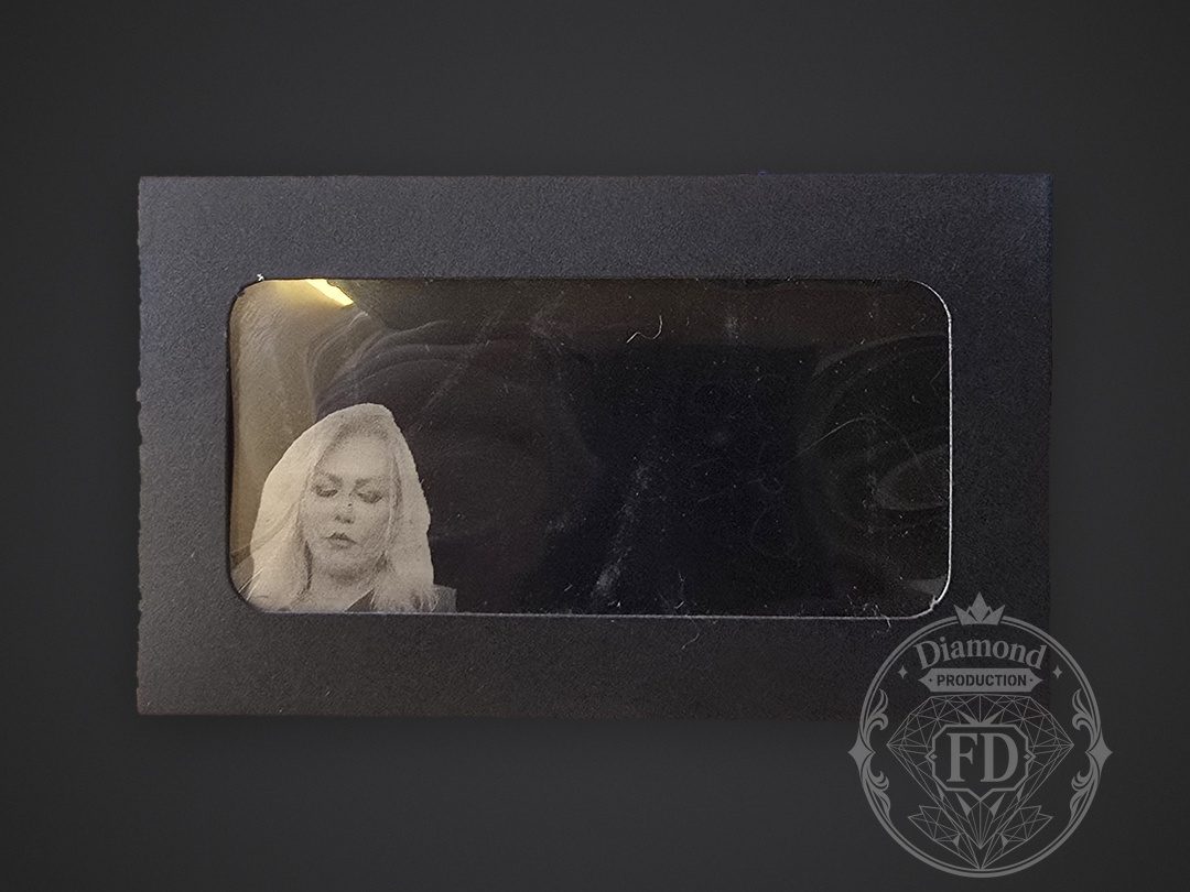 Engraved metal card displayed inside a black gift box with a clear window